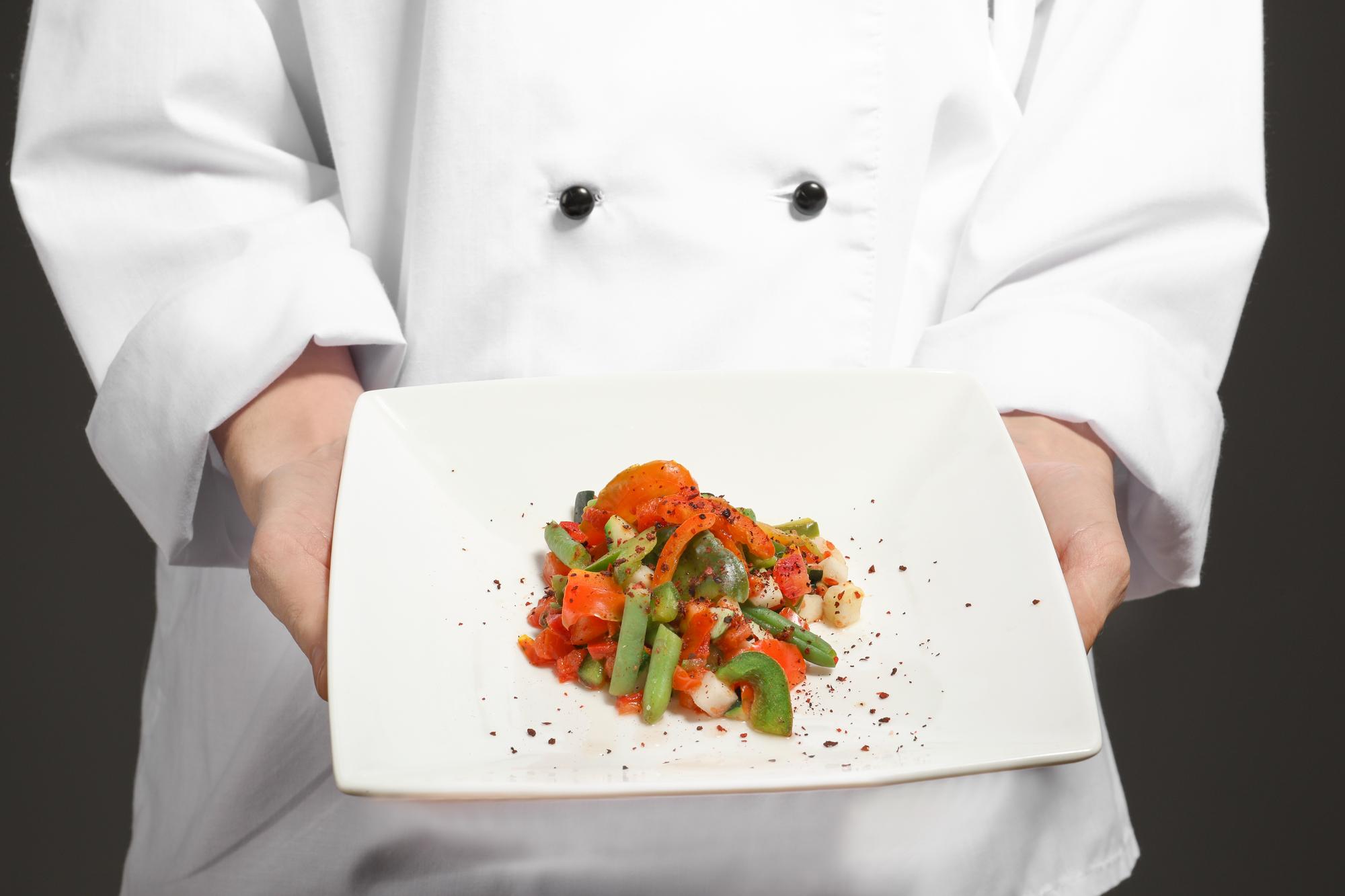 Chef preparing plated dish in kitchen studio
